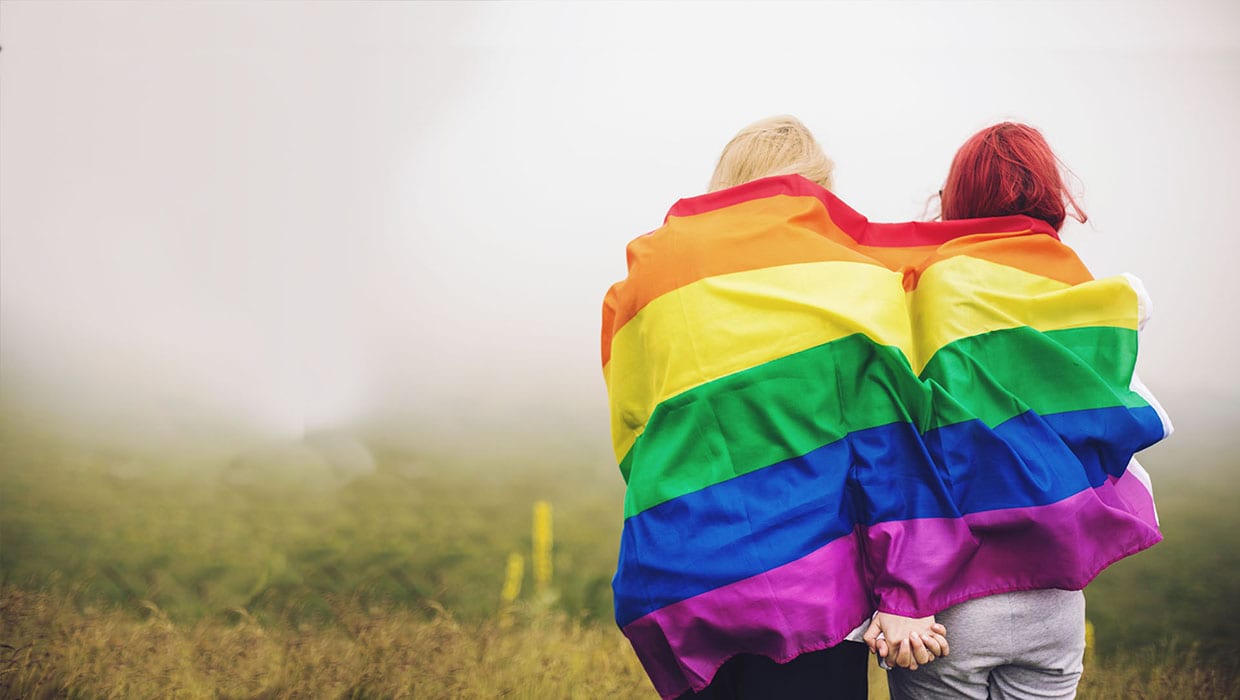 LGBT flag over two people embracing